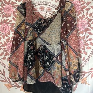 A size medium blouse. Has different colors and patterns with a neutral colors.
